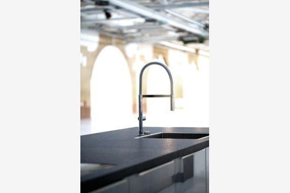 Küchenarbeitsplatte aus Granit-Naturstein mit Unterbauspüle und hoher Armatur – Detail in moderner Küche