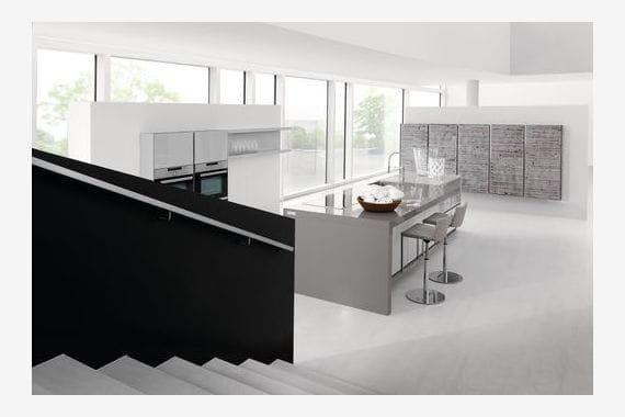 Offene Küche mit langem Küchenblock, Sitzplätzen und dunkler Naturstein-Arbeitsplatte aus Granit in modernem Loft