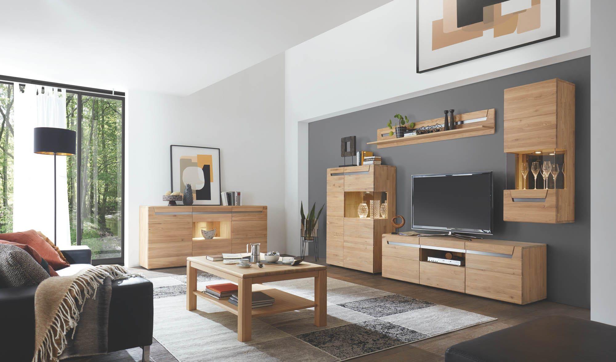 Stilvolles Wohnzimmer mit moderner Wohnwand in Holzoptik: TV-Board, Wandregale, beleuchtete Vitrine und Sideboard, ergänzt durch Couchtisch und Sofa im hellen Raum