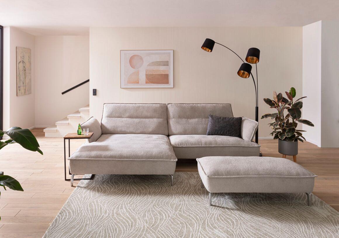 Sofa Samba von Komfort & Wohnen mit Longchair und separatem Hocker in hellgrauem Stoff für stilvolles Wohnen.