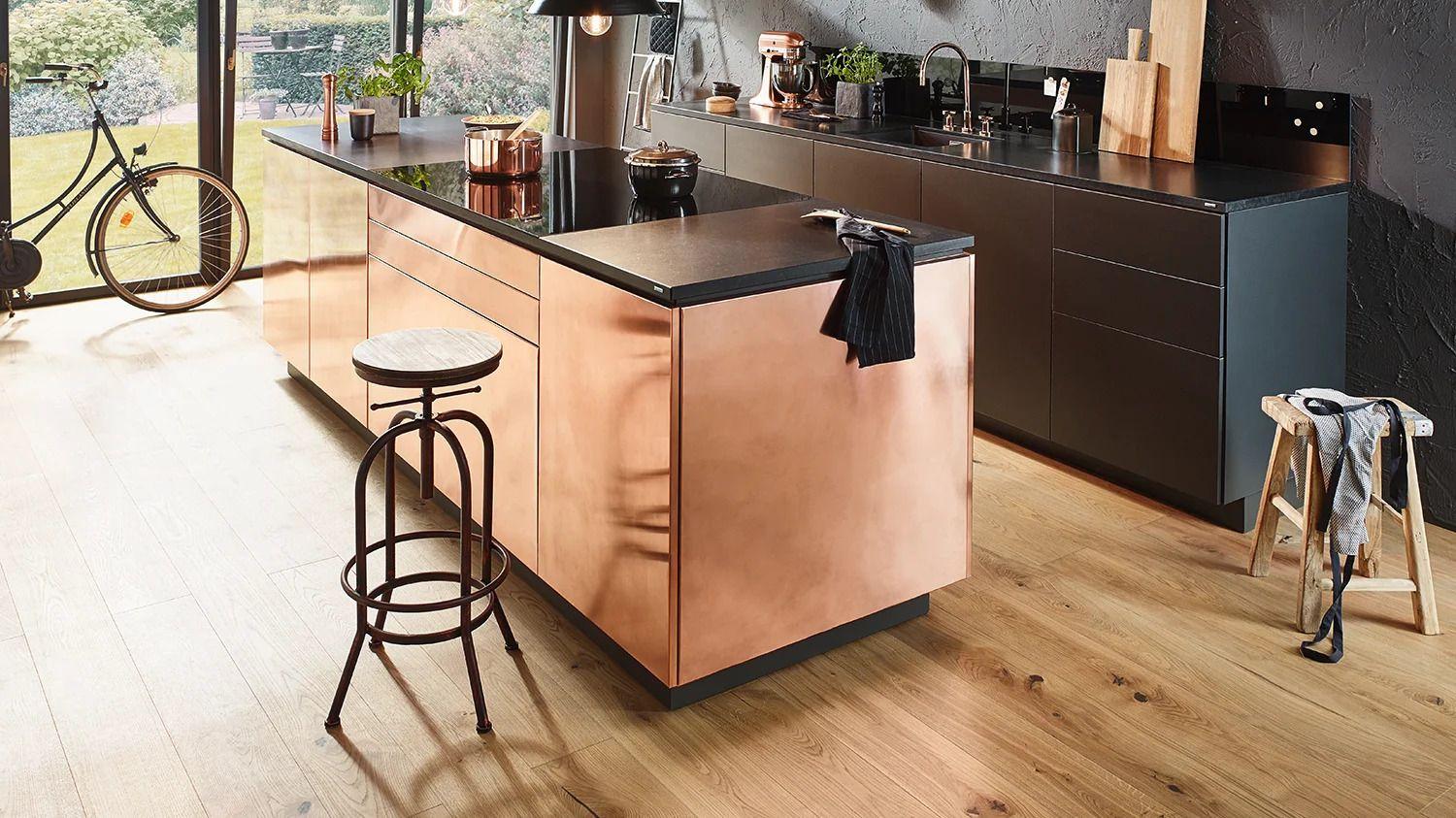 Lechner Naturstein-Arbeitsplatte Nero Assoluto Z in elegantem Schwarz mit strukturierter Oberfläche und Kupferdetails.